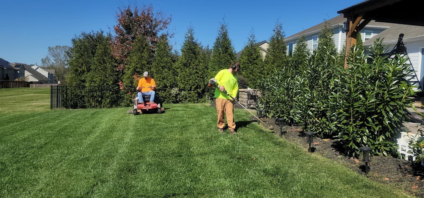 Marion Precision crew mowing and edging a residential lawn