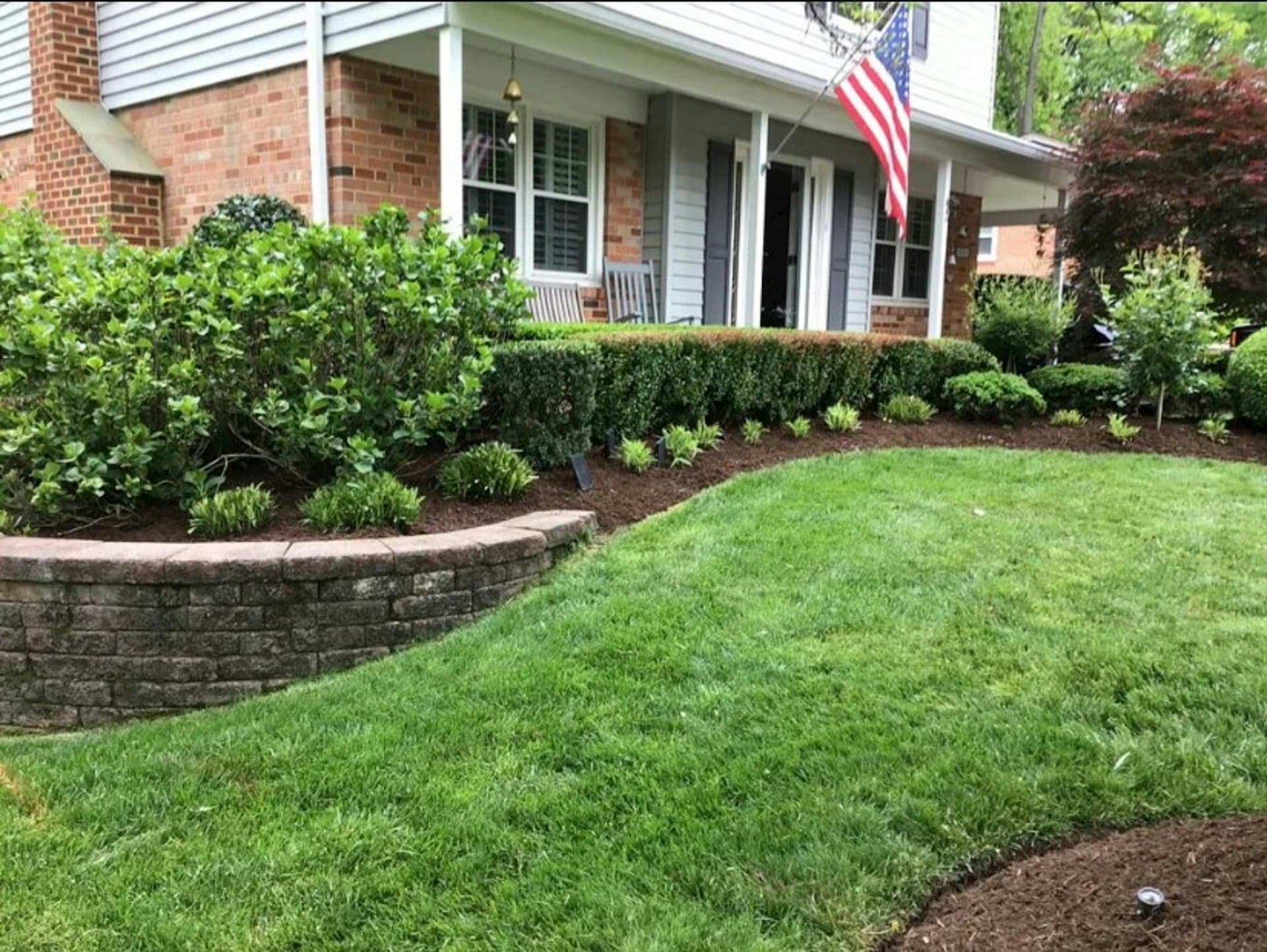 Immaculate residential lawn with landscaped beds and stone retaining wall in Ocala, Florida